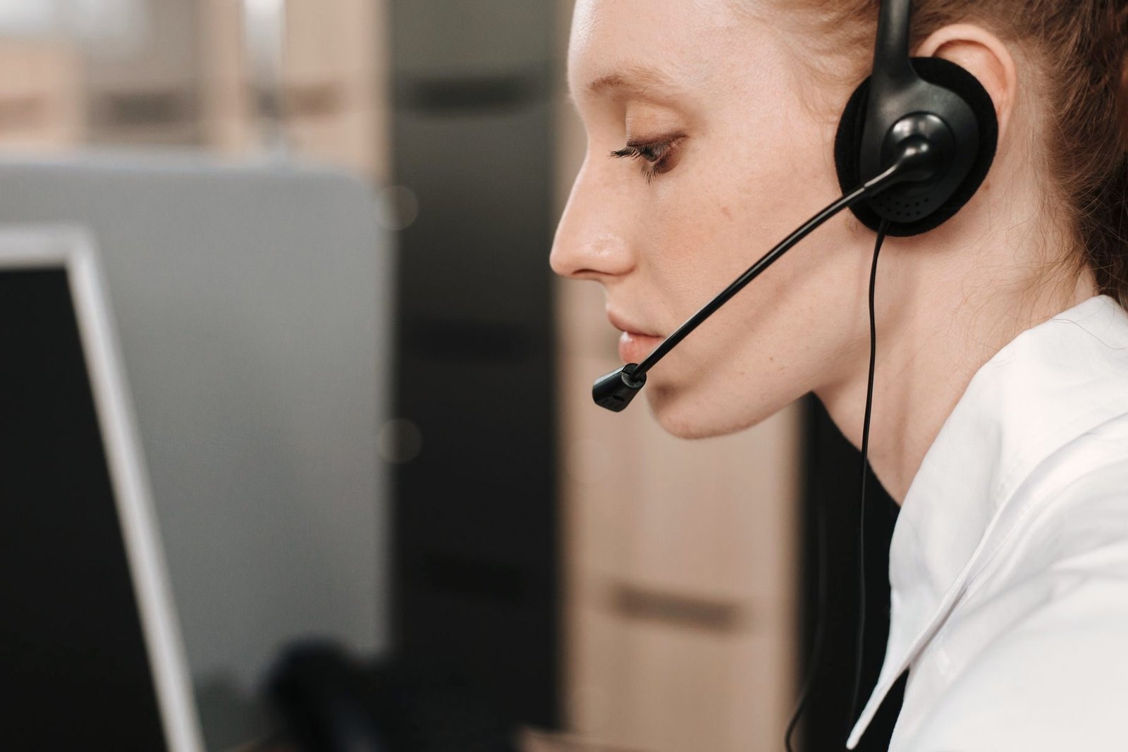 An operator wearing a headset in profile at a workstation