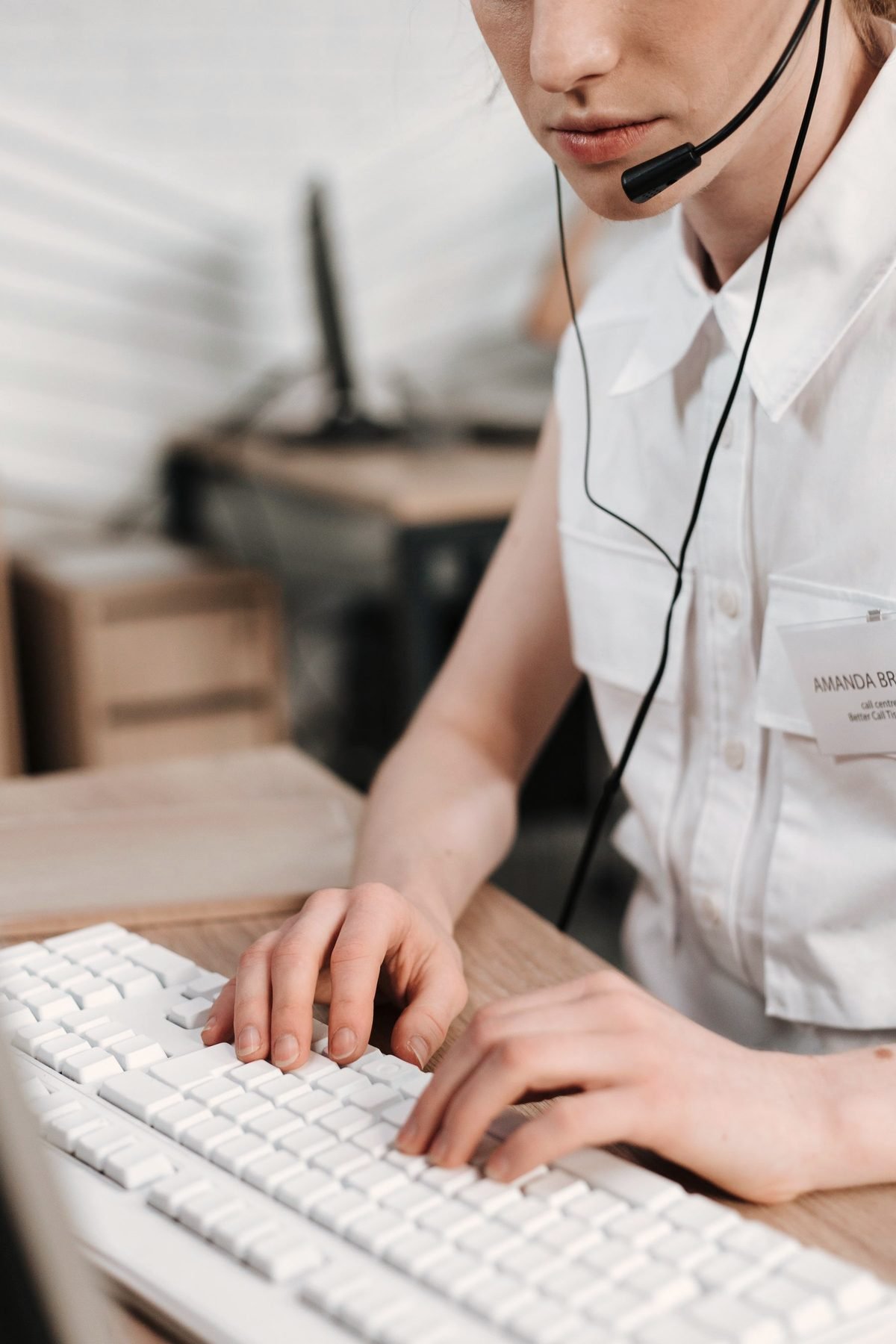 An operator typing a caller's details at a keyboard